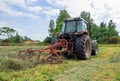 young woman in tractor turning hay in pasture Royalty Free Stock Photo