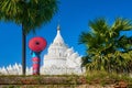 Young woman in traditional dress is looking at a pagoda near the ancient city of Mandalay, Myanmar