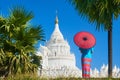 A young woman in traditional dress is looking at a pagoda near the ancient city of Mandalay, Myanmar