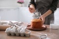 Young woman with traditional Easter cake in kitchen, closeup. Space for text Royalty Free Stock Photo