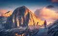 Young woman on the trail looking on high mountain peak at sunset