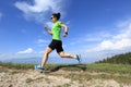 Young woman trail runner running on beautiful mountain peak Royalty Free Stock Photo