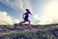 Young woman trail runner running on beautiful mountain peak Royalty Free Stock Photo