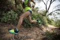 woman trail runner running on tropical forest trai