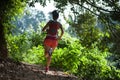 Woman trail runner running on tropical forest trail Royalty Free Stock Photo