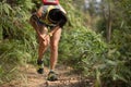 woman trail runner sports injured legs while running on tropical forest trail Royalty Free Stock Photo