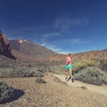 Young woman trail running in mountains on sunny day Royalty Free Stock Photo