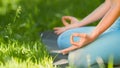 Young woman trainer in blue tracksuit meditates in yoga pose lotus holding hands on knees in leggings