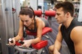 Young woman with trainer exercising on gym machine Royalty Free Stock Photo