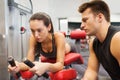 Young woman with trainer exercising on gym machine Royalty Free Stock Photo
