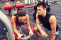 Young woman with trainer exercising on gym machine Royalty Free Stock Photo