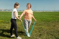 Young woman trainer helps senior woman doing stretching exercises.