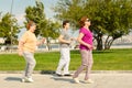 Young woman trainer helps senior woman doing stretching exercises