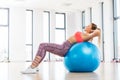 Young woman training with fitball at fitness club. Royalty Free Stock Photo