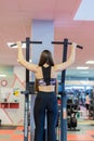 Young woman training in the gym. Pulling in gravitrone. Royalty Free Stock Photo