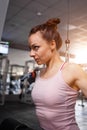 Young woman training lats on cable machine in gym