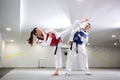 Young woman training martial art of taekwondo with her coach