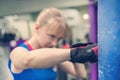 Young woman training punch boxing gloves for punching bag. Girl making Strong kick. Cross Fit. Training melee. Women`s fight with