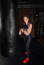 Young woman trains in boxing ring with heavy punching bag. Royalty Free Stock Photo