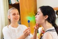 Young woman trains with speech therapy probe in soft focus