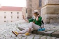 Young woman travel alone in old city centre, sitting and taking selfe. Royalty Free Stock Photo