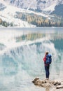 Young woman traveler in Alps mountains looking on a lake. Travel, winter and active lifestyle concept Royalty Free Stock Photo