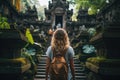 Young woman traveler with backpack walking at Pura Besakih temple in Bali, Indonesia, Tourist woman with backpack at vacation