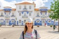 Young woman traveler with hat looking at camera posing and smiling in streets of Aveiro city in Portugal