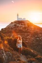 Young woman traveler hiking outdoor   travel healthy lifestyle active vacations girl enjoying sunset lighthouse view Royalty Free Stock Photo