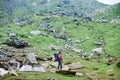 Young female climber on rock near tent on green rocky slope in mountains in Romania Royalty Free Stock Photo