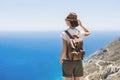 Young woman traveler looking at the sea. Beautiful girl enjoying nature. Summer holiday, vacation, travel, tourism concept