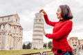 Woman traveler making funny poses in front of the famous leaning tower in Pisa, Italy. Happy travel photos in Italy concept Royalty Free Stock Photo