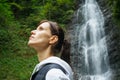 Young woman traveler observes a waterfall