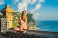 Young woman traveler in Pura Luhur Uluwatu temple, Bali, Indonesia. Amazing landscape - cliff with blue sky and sea Royalty Free Stock Photo