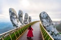 Young woman traveler in red dress enjoying at Golden Bridge in Bana hills, Danang Vietnam, Travel lifestyle Royalty Free Stock Photo