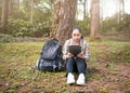 Young woman traveler searches GPS coordinates by tablet PC at nature trail in summer vacations day. Technology and Travel concept