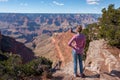 Young woman traveler standing at the edge of the cliff and admire the Grand Canyon National Park in Arizona USA Royalty Free Stock Photo