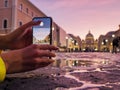 Young woman traveler tourist taking beautiful landscape photo of european sunset during holiday vacation Royalty Free Stock Photo