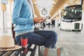 Young woman traveler waiting for a bus on a bus station and using digital tablet, travel and active lifestyle concept Royalty Free Stock Photo