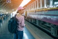 Young woman traveler waiting for a train on a train on platform of railway station, travel and active lifestyle concept Royalty Free Stock Photo