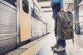 Young woman traveler waiting for a train on a railroad station, travel and active lifestyle concept Royalty Free Stock Photo