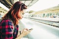 Young woman traveler wearing backpack waiting railway at train station