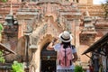 Young woman traveling backpacker with hat, Asian traveler looking Beautiful ancient temples and pagoda, landmark and popular for Royalty Free Stock Photo