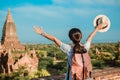 Young woman traveling backpacker with hat, Asian traveler standing on Pagoda and looking Beautiful ancient temples Royalty Free Stock Photo