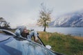 Young woman traveling by car standing against the backdrop of a beautiful mountain landscape with a lake Royalty Free Stock Photo