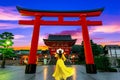 Young woman traveling at Fushimi Inari taisha Shrine at sunrise, landmark and popular for tourists attractions in Kyoto,Japan