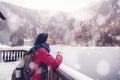 A young woman traveling in the mountains in winter, drinking hot tea against the backdrop of a frozen lake, the Alps Royalty Free Stock Photo