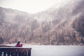 A young woman traveling in the mountains in winter, drinking hot tea against the backdrop of a frozen lake, the Alps Royalty Free Stock Photo
