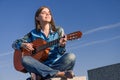 Young woman traveller with guitar outdoor on sea coast Royalty Free Stock Photo