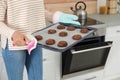 Young woman with tray of oven baked cookies in kitchen Royalty Free Stock Photo